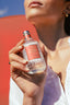 Acqua Colonia Fig & Vetiver vom Model haltend vor roter Wand
