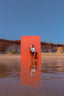 Acqua Colonia Model vor rotem Hintergrund am Strand